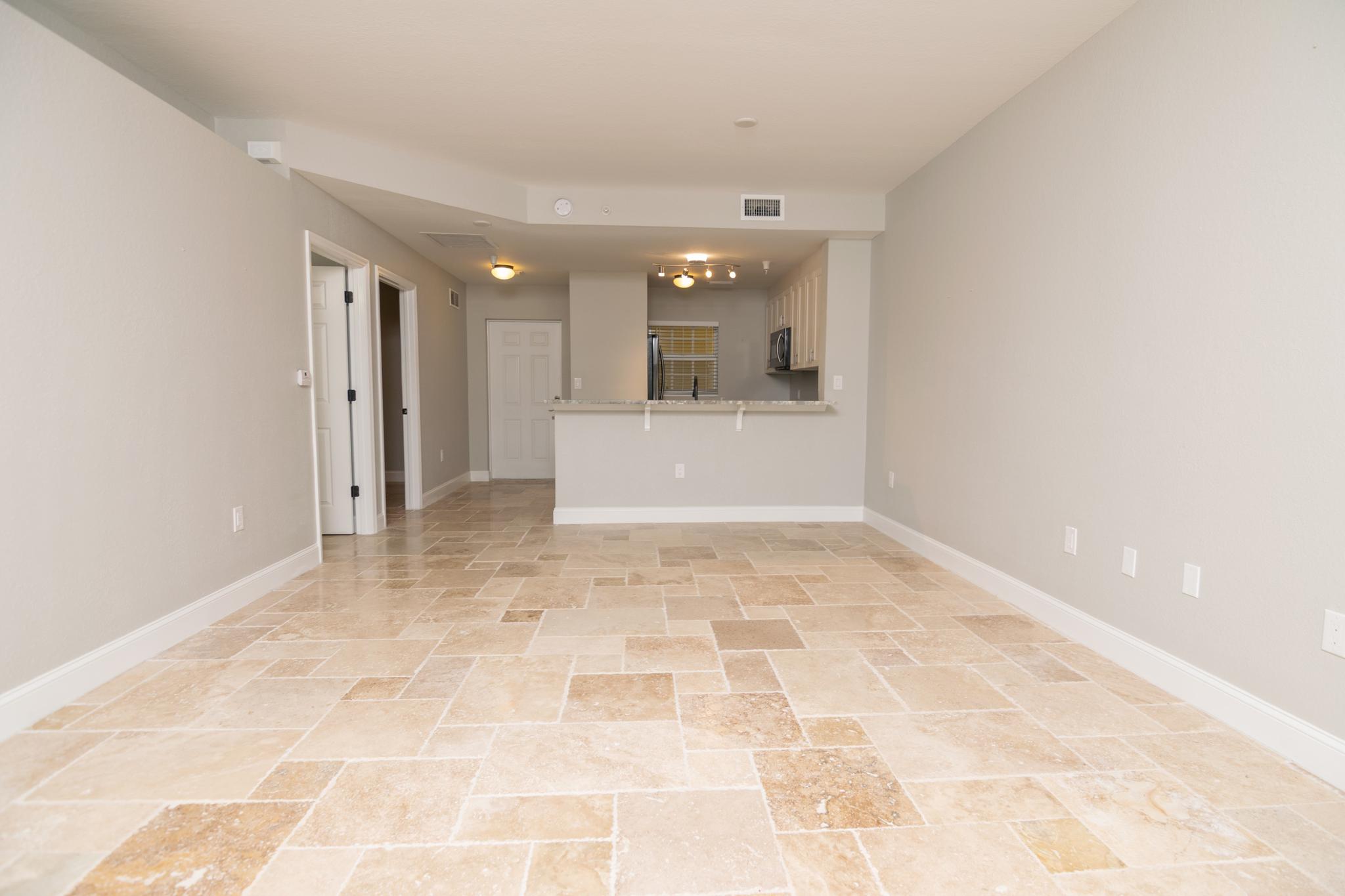 The family room of the condo is large and the whole condo has travertine tile throughout