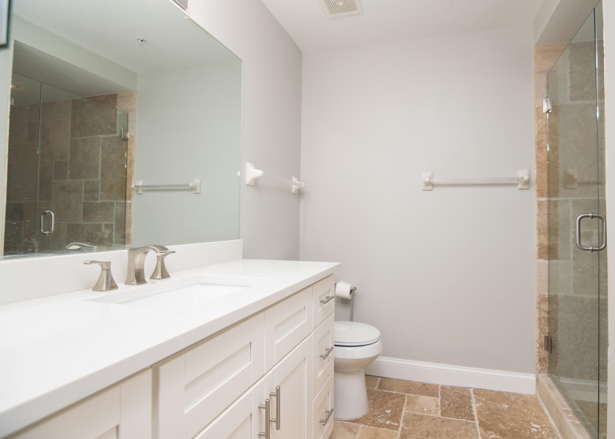 The en suite main bathroom has a modern vanity and a glass enclosed shower