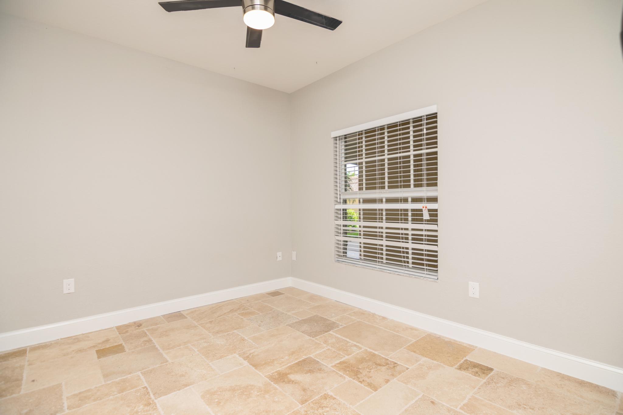 The second bedroom with a window looking towards the outside hallway